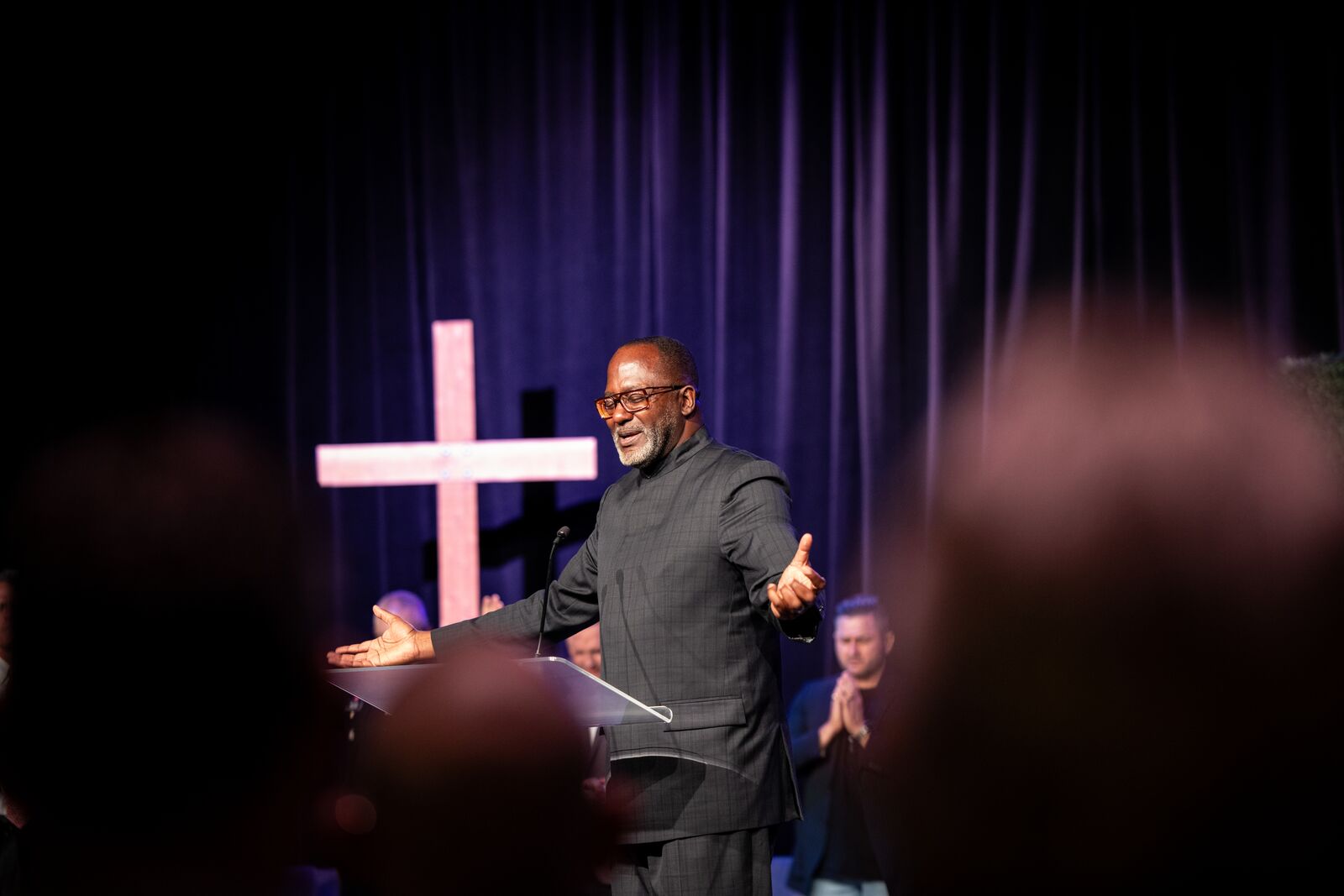 National Day of Prayer speaker on stage in front of an illuminated cross